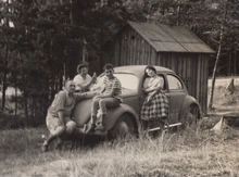 Schwarzweißfoto von Familie Tal mit VW-Käfer 959